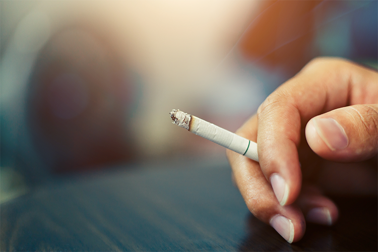 Hand holding a cigarette - Smoking and Sleep Apnoea | SleepTest.co.uk