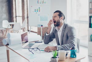 Man yawning at desk - Sleep Apnoea daytime sleepiness | SleepTest.co.uk